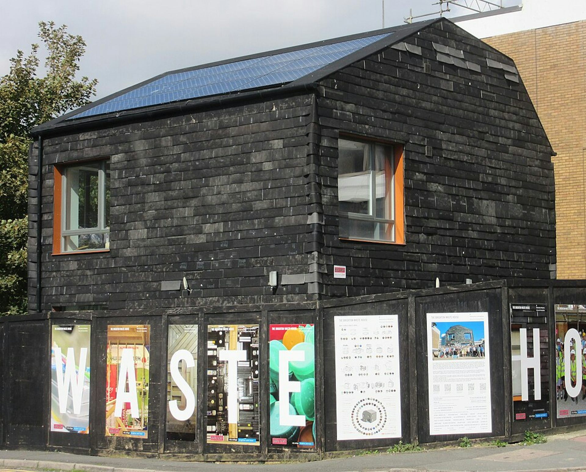 Black building Waste House in Brighton, WASTE HOUSE signs outside