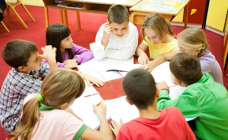 Children around the table are working together