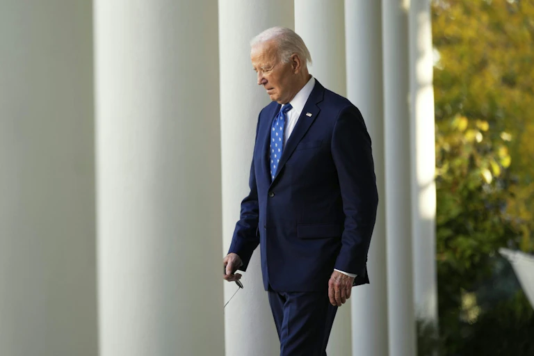 Joe Biden passando por colunas brancas