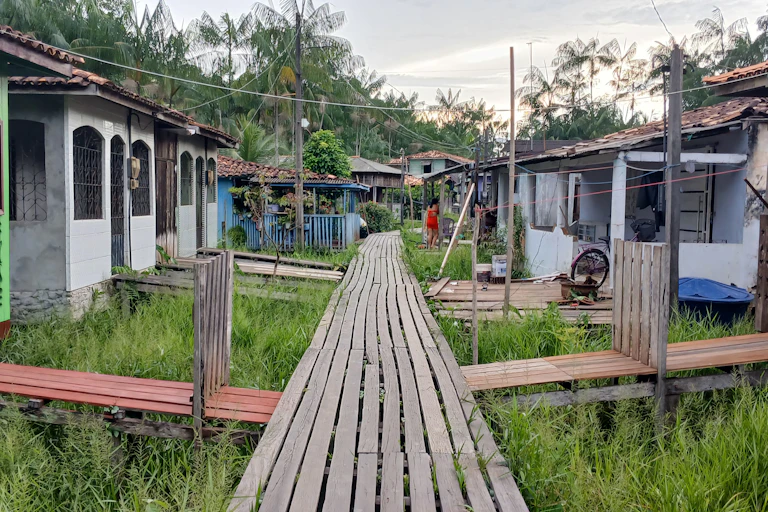 Foto mostra casas sobre palafitas, unidas a uma espécie de ponte de madeira onde se caminha a pé