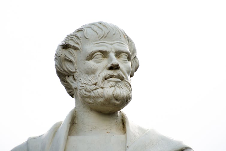 A sculpted white head of a beadrded man.