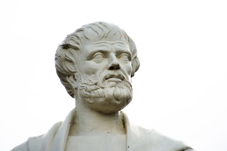 A sculpted white head of a beadrded man.