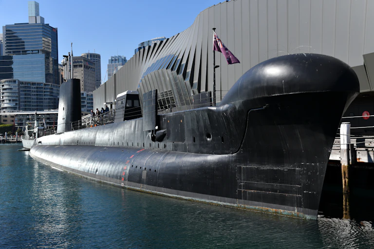 A surfaced black submarine in dock