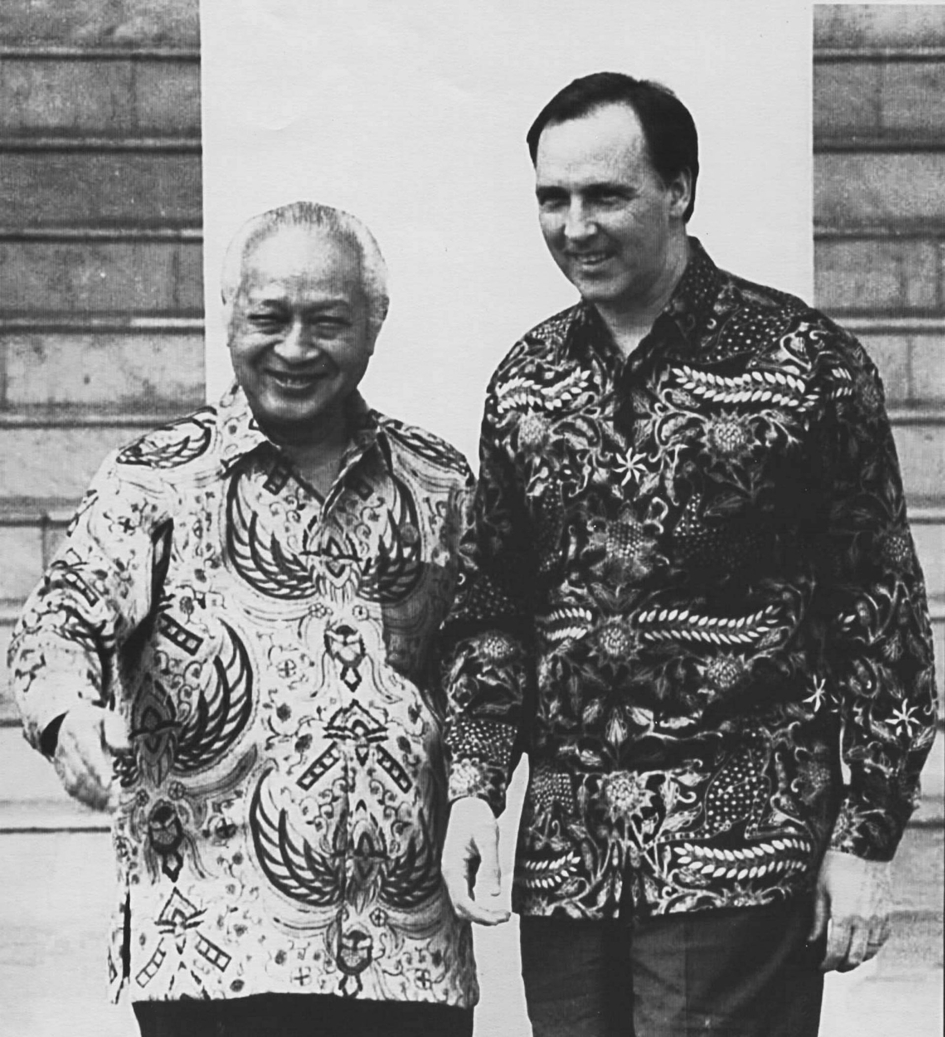 Suharto and Keating in printed shirts in a black and white photograph.
