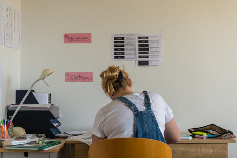 A young woman studies at a desk.