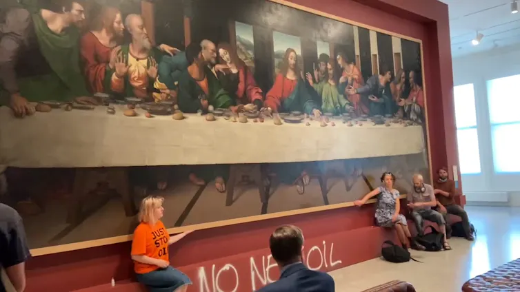 Just Stop Oil protestors with hands glued to the frame of da Vinci's The Last Supper.