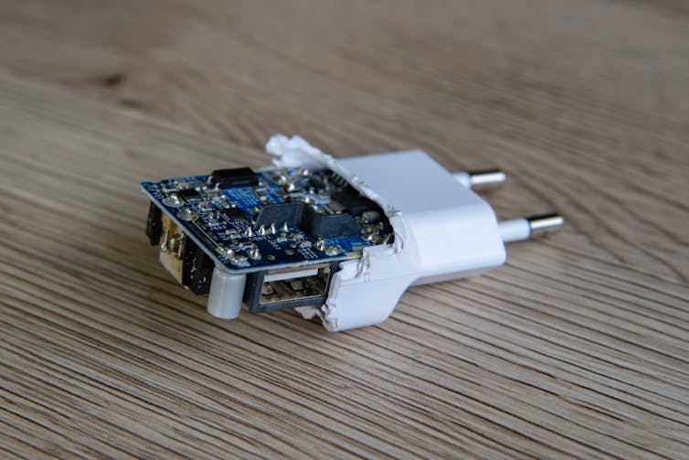 A partially broken charger with two prongs and the internal chips exposed.