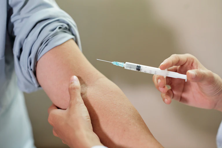 Vacunación con una jeringuilla en un brazo