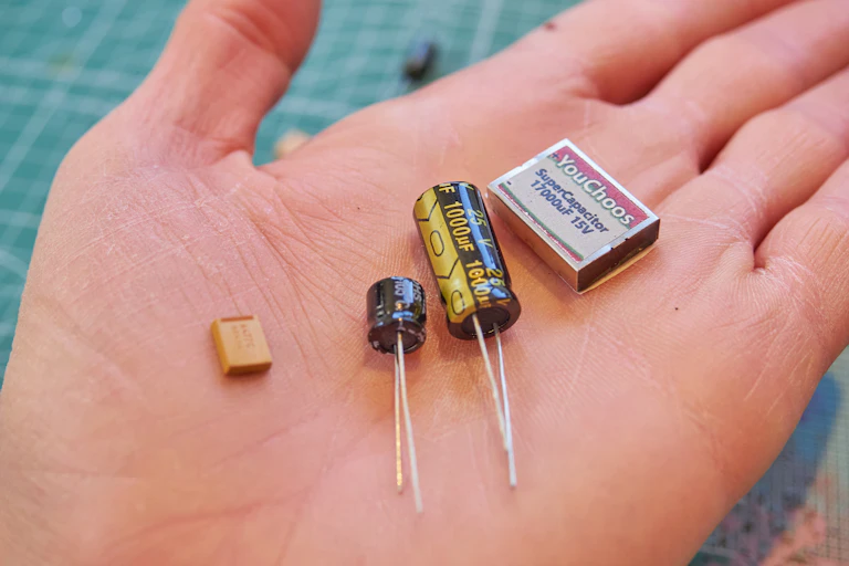 Small cylindrical and rectangular objects in the palm of a hand