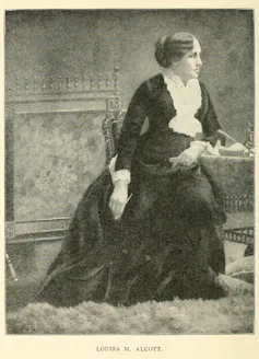 Retrato de una mujer vestida de negro sentada y apoyada en una mesita.