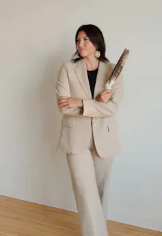 a closeup of a woman chief in a suit carrying a feather
