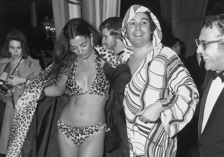Woman wearing leopard-print bikini and leopard-print shawl.