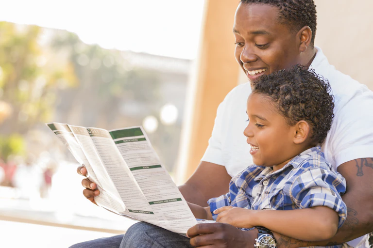 A father with a chld looking at a brochure.