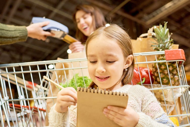A child with a notepad at grocery store.