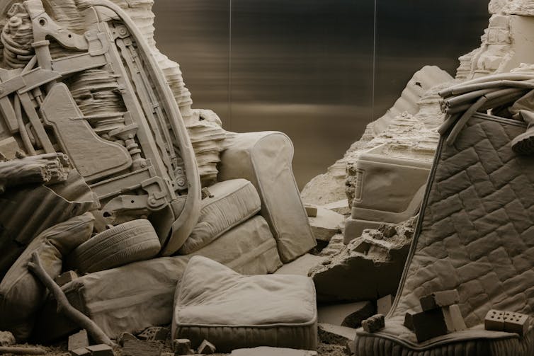 Close up: a couch, an upturned car.