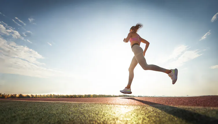 A woman goes for a run at sunset.