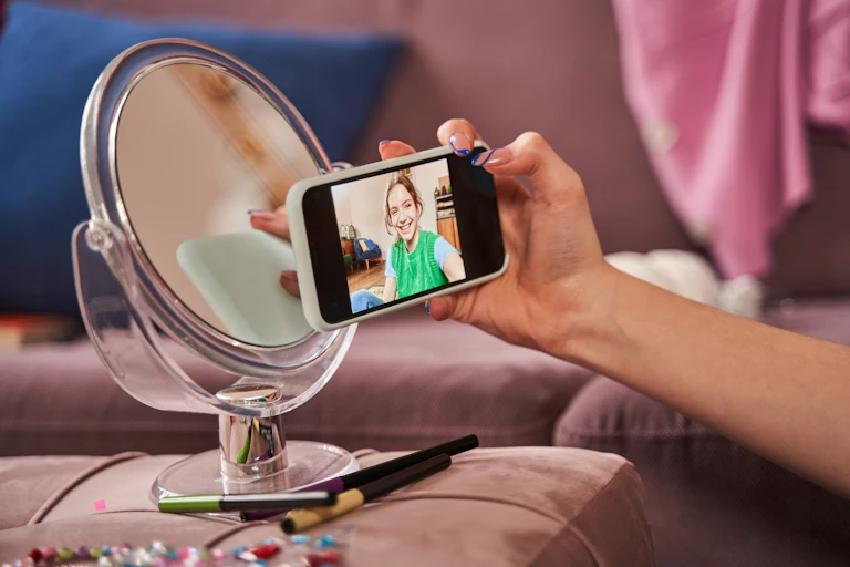Cropped view of the teenager girl making selfie at her smartphone.