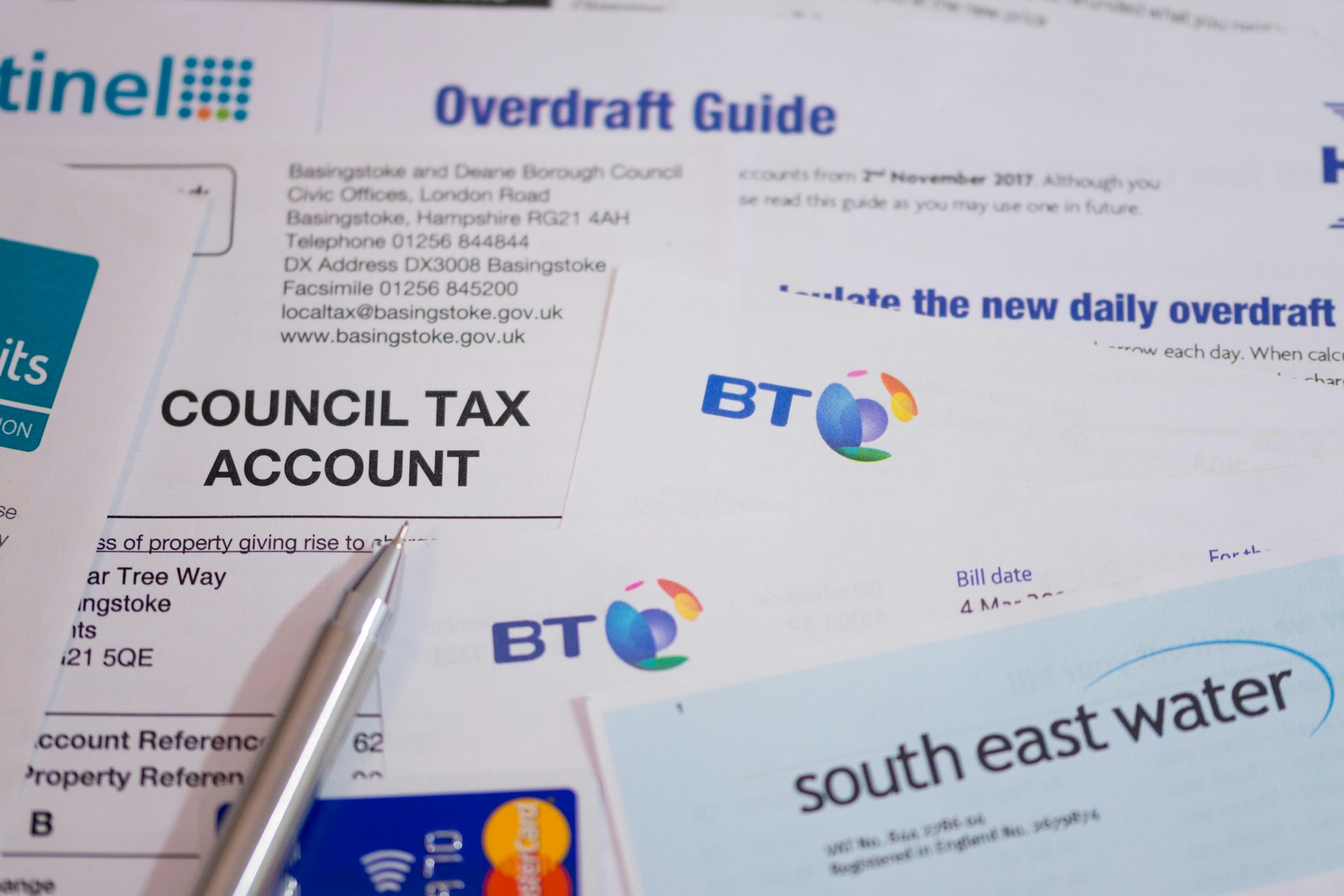 A selection of bills, a credit card and a guide to overdrafts.