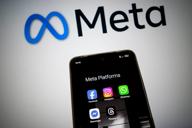 Meta platforms display on a smartphone screen, and the Meta logo appears in the background