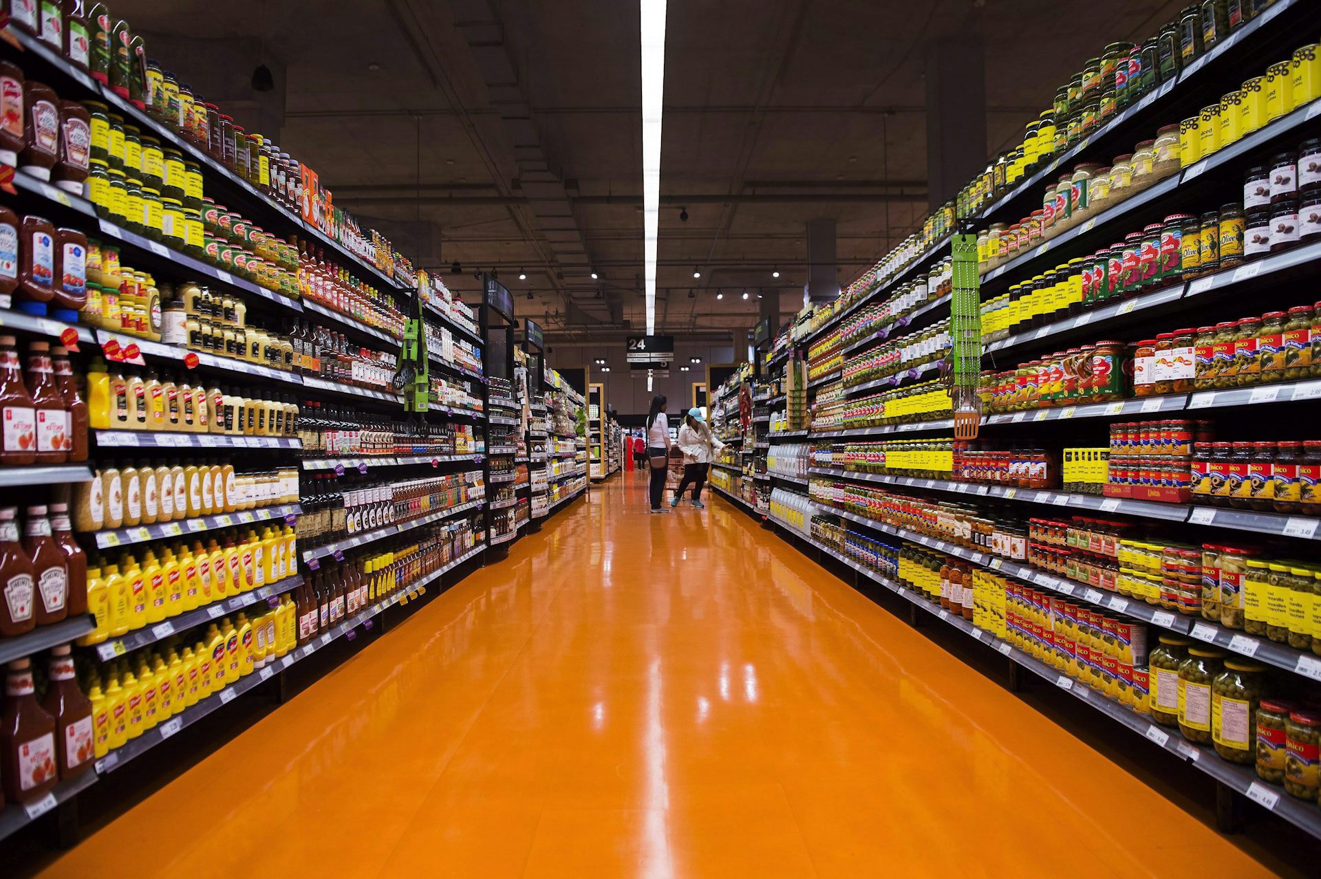orange tiled grocery store aisle with shelves of food on either side