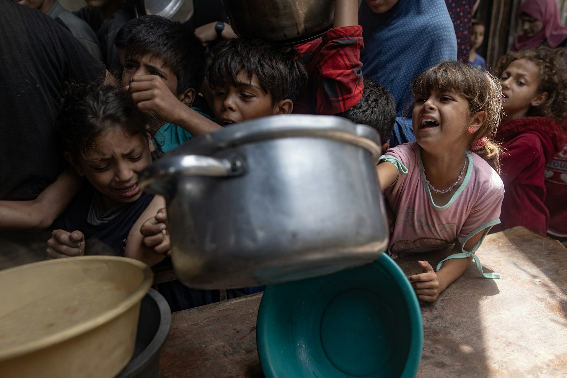 Gazan children gathered at a charity kitchen to receive food rations.