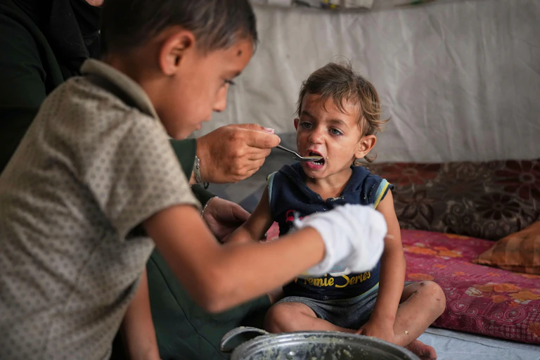 A young boy is fed at a community kitchen in Gaza.