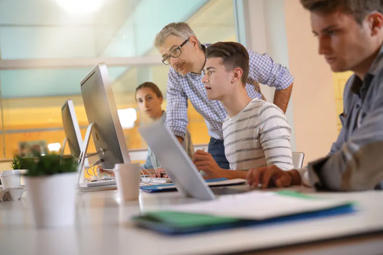 Group of students at computers and teacher