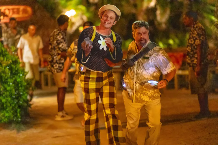 Two men garishly in flamboyantly patterned clothes and hats.