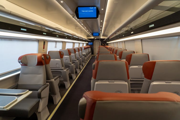 Interior of modern train with seats with red headrests