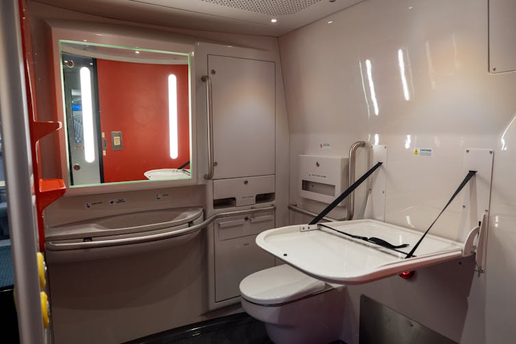 Modern white-and-red bathroom with changing table open