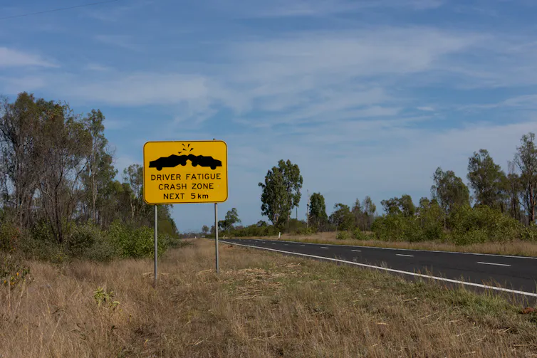 Large yello sign by a road in the country