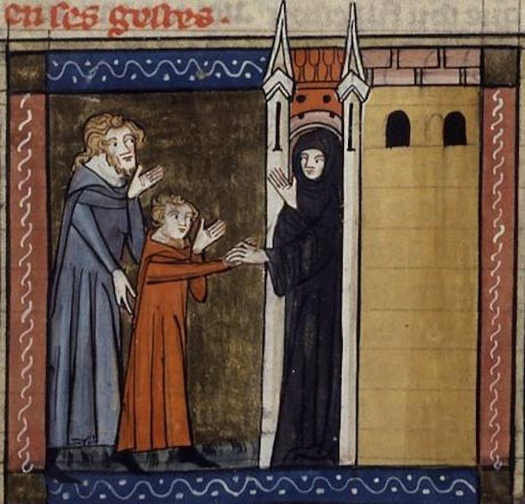 A child and an older man stand at the entrance of a building with minarets as a nun, clad entirely in black, talks to them.