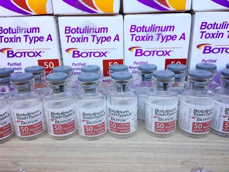 Small vials of clear liquid lined up on a bench top.