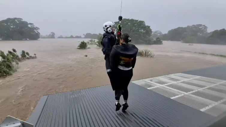 NSW Police use a helicopter to rescue residents from their rooftops from floodwaters in Taree, New South Wales
