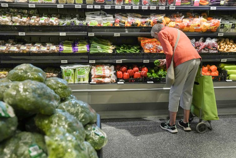 Una mujer que revisa productos frescos en el supermercado