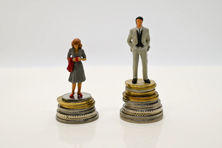 deux figurines, l'une masculine, l'autre féminine sur un petit tas de pièce pour symboliser les écarts salariaux