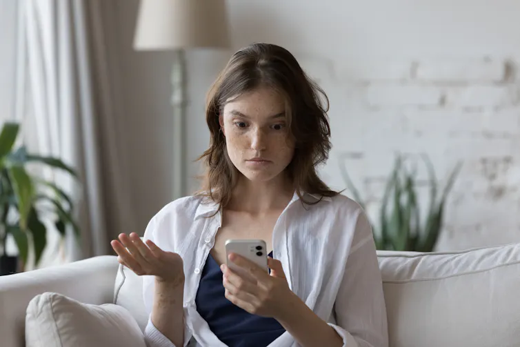 Woman looking annoyed and upset at phone