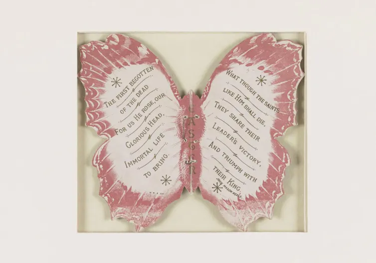 A red-and-white cardboard butterfly with text written on the wings.