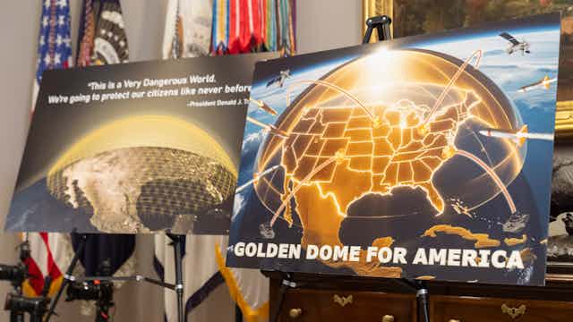 two posters on easels depict golden hemispheres covering maps off the United States