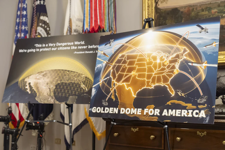 two posters on easels depict golden hemispheres covering maps off the United States