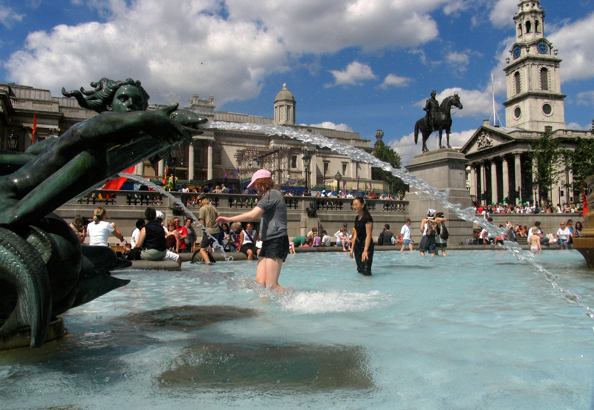 People play in the fountains in Trafalgar Square on a hot day in London.