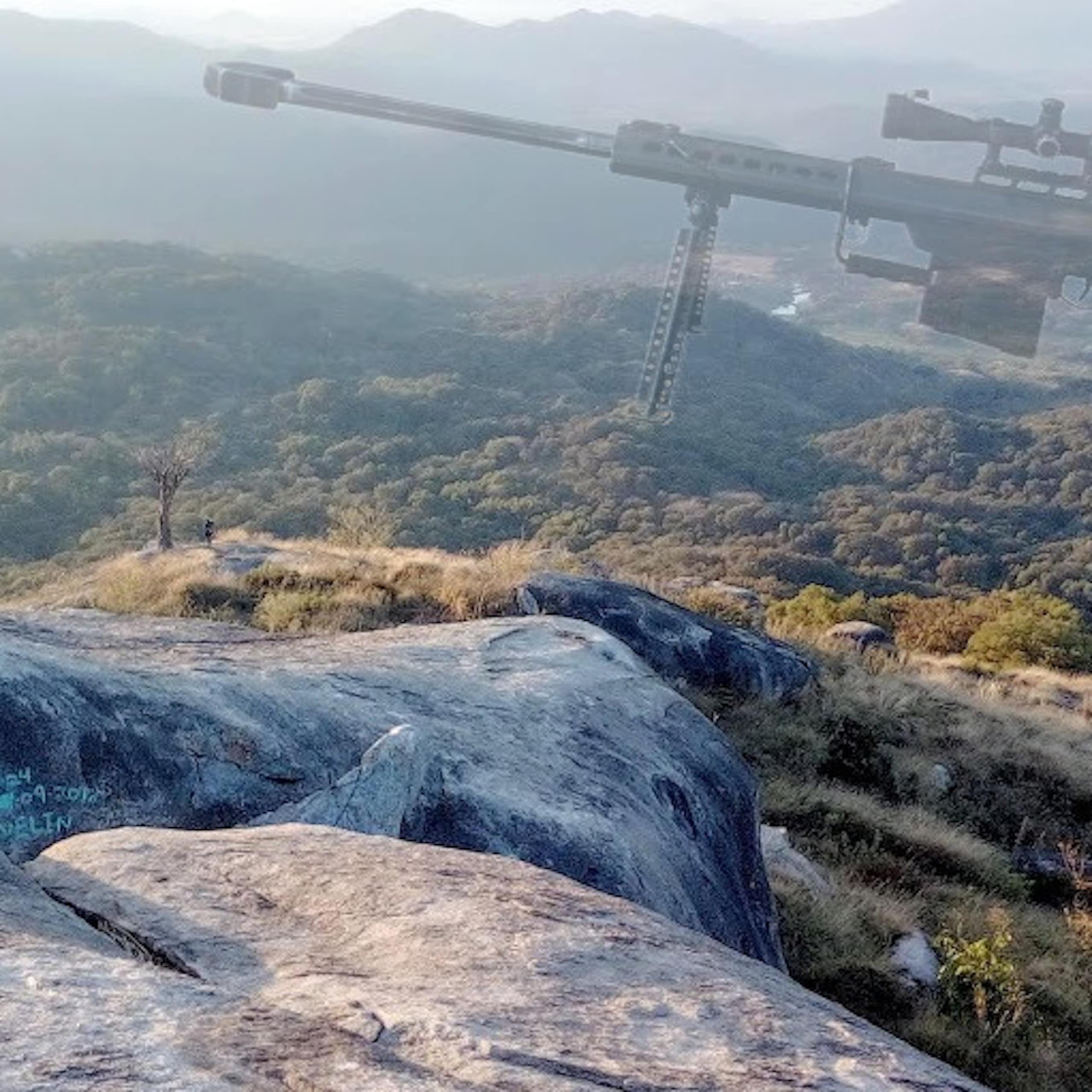 A rocky path near a grassy field with an image of a gun superimposed over it.