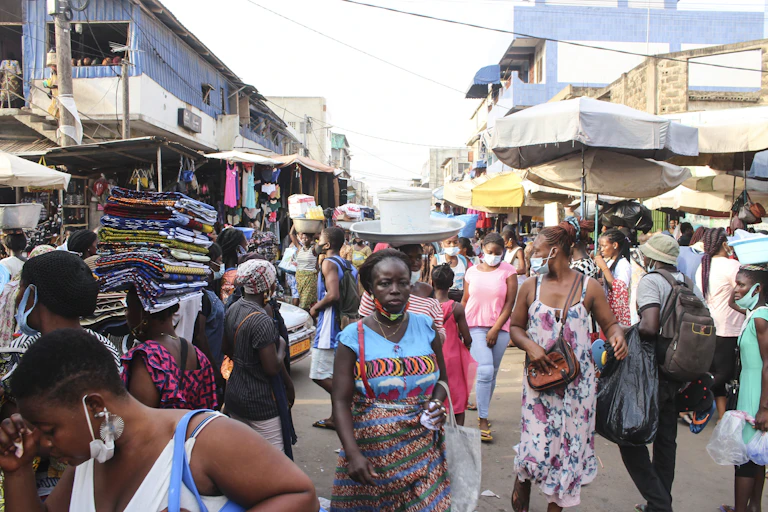 Men and women moving around in an open market