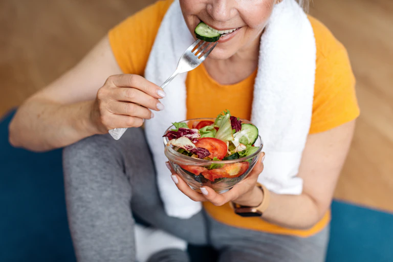 Mulher esportiva comendo uma salada