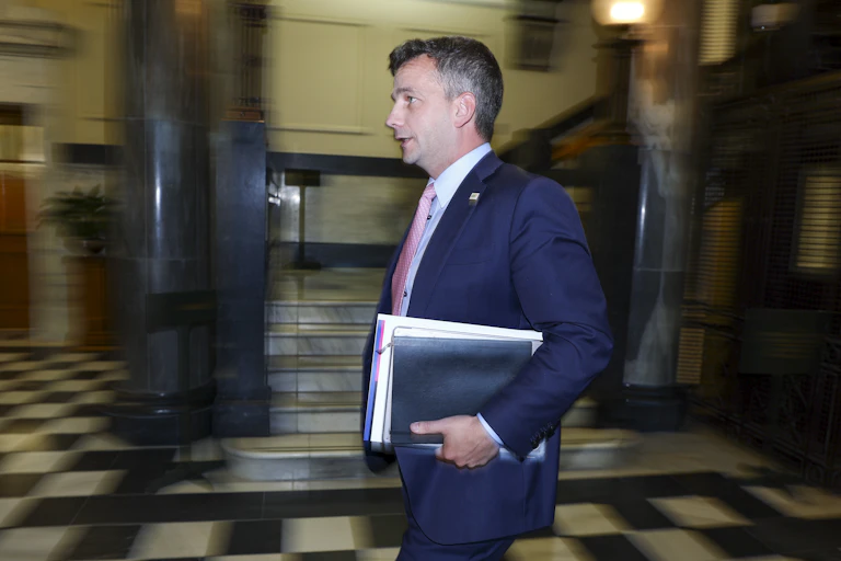 David Seymour holding documents walking in parliament