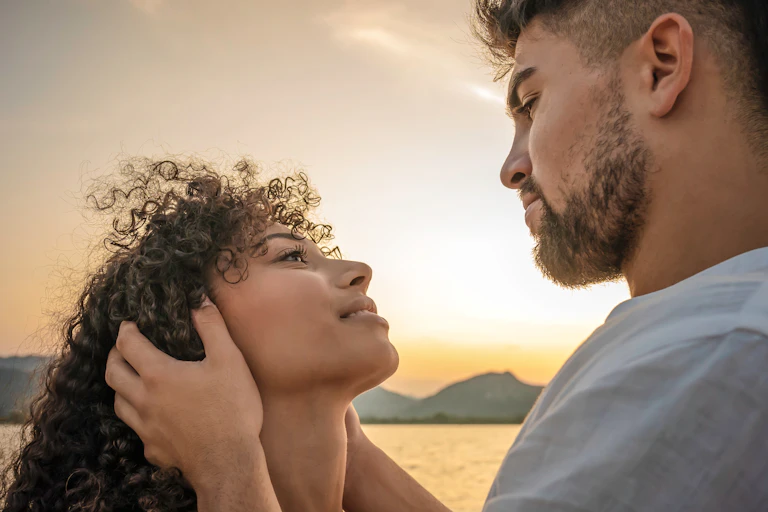 A man and a woman look into one another's eyes romantically.