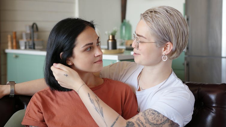 A woman smiles gently as she stares into the eyes of her lover.