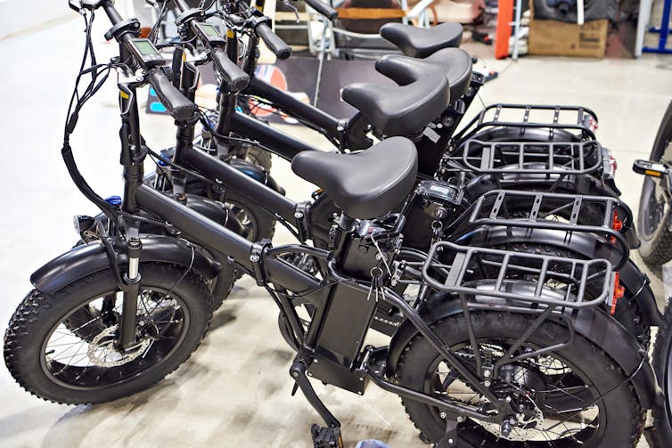 Black electronic bikes on a shop floor.