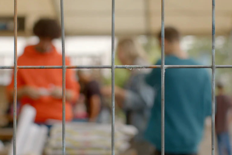 Young people are seen behind bars