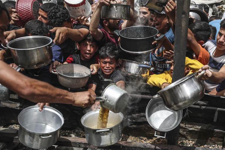 A child's face is seen between various people holding pans.